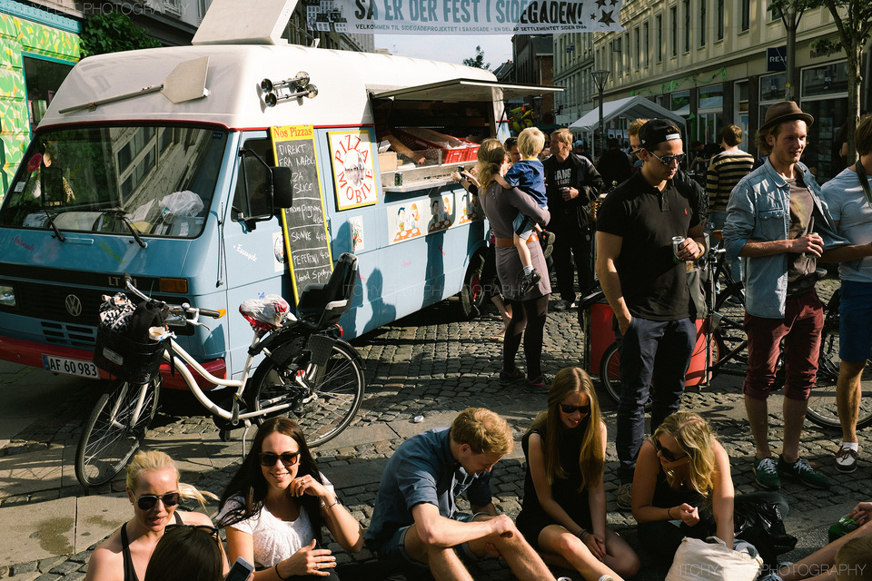 People enjoying the sun and some pizza from the funky pizza van